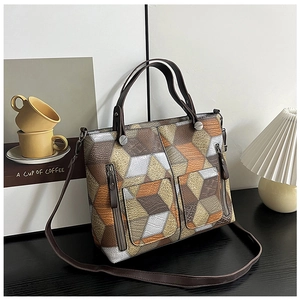 Detail of color-block tote bag featuring litchi texture and front zipper pockets