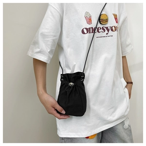 Detail of black drawstring bucket bag with silver eyelets and slender leather strap