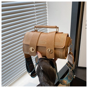 Détail du sac à bandoulière rétro beige avec boucles dorées et sangle tissée