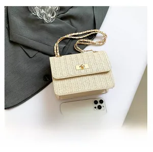 Détail du sac bandoulière en paille tressée avec fermoir doré et smartphone pour la taille