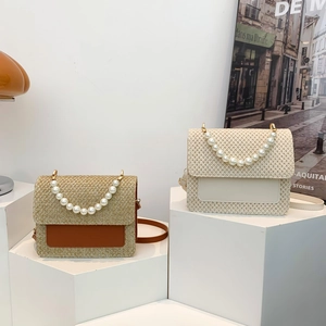French straw crossbody bag with pearl handle and golden hardware in brown and beige