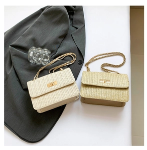 Detailed view of beige and brown woven straw crossbody bags with metal chain straps