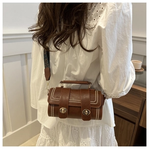 Detail of vintage brown Boston bag with dual locks and ethnic patterned shoulder strap
