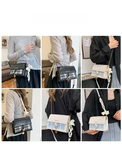 Detail of contrast plaid crossbody bag with silk ribbon bow and metal chain strap