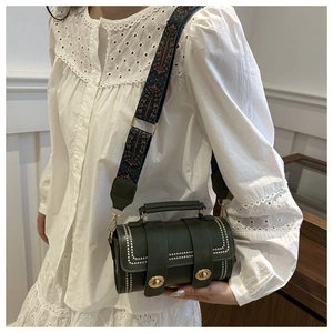 Detail of dark green leather bucket bag with silver rivets and golden twist locks