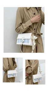 Detail of crossbody bag featuring plaid tweed texture and elegant silk scarf handle