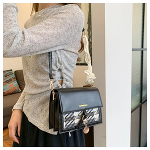Detail of tweed crossbody bag with gold hardware and silk scarf strap on model