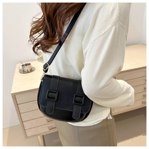 Detailed side view of a black retro saddle crossbody bag with dual decorative buckles