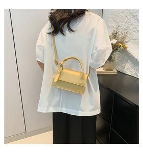 Détail du sac à rabat en cuir jaune moutarde avec poignée et logo en relief chic