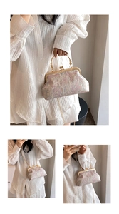 Detail of vintage floral jacquard fabric and golden metal clasp on a crossbody bag