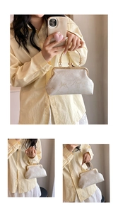 Detailed view of embroidery pattern and golden metal clasp on beige retro cheongsam bag
