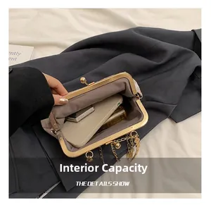 Detail showing inner capacity of a champagne fabric handbag with a vintage gold clasp