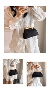 Detail of black satin kiss-lock bag with floral texture, gold ring handle and chain strap