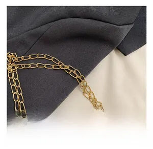 Detail shot of dual gold metallic chains on black fabric for a chic women shoulder bag