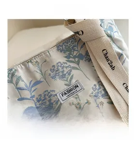 Close-up of floral canvas tote bag featuring premium fabric texture and woven strap details