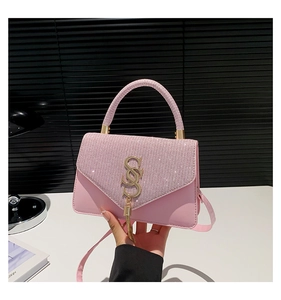 Detail of pink rhinestone handbag featuring golden SS buckle and stylish tassel charm