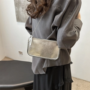 Sac bandoulière argenté en cuir texturé avec chaîne en métal et rivets élégants