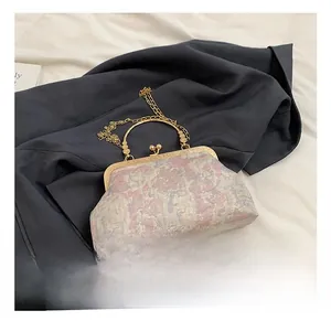 Detail of vintage floral jacquard handbag with metal ring handle and gold chain strap