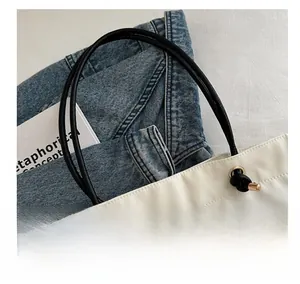 Detail of canvas tote bag showing black CD print and reinforced rope handle