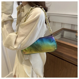 Detail of a chic rainbow gradient shoulder bag with a chunky gold chain strap