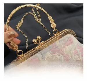 Close-up of vintage pink floral jacquard evening bag with engraved gold hardware clasp