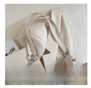 Close-up of floral tote bag with cream leather handles and gold chain hardware detail