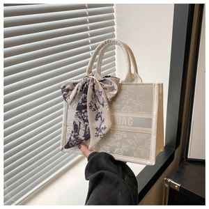 Elegant cream canvas tote bag with floral embroidery and silk ribbon on handle