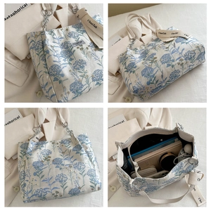 Detail of floral canvas tote bag showing spacious interior and chain shoulder strap