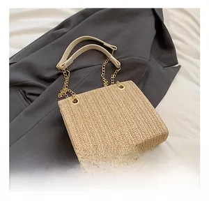 Detailed V-pattern straw texture of the beige shoulder bag with gold chain strap