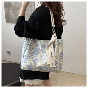 Close-up of floral print tote bag with satin finish and fashion instinct brand label