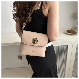 Detail of a beige leather crossbody bag featuring a golden vintage logo and adjustable strap