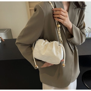 Borsa a spalla bianca plissettata a nuvola con catena a sfere dorate indossata