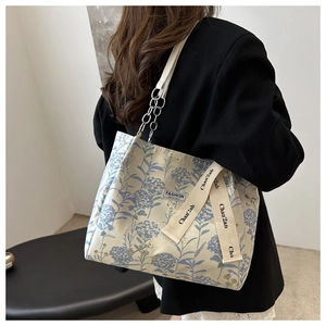 Detail of floral canvas tote bag with metal chain strap and embroidery pattern