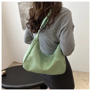Minimalist light green nylon hobo bag shown on model back for lightweight style