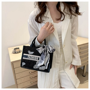 Detail of black canvas tote bag with white butterfly print and fashion scarf handle
