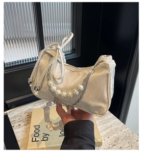 Détail du sac nuage plissé blanc avec anse en perles et bandoulière en chaîne