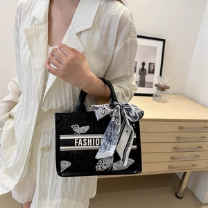 Black embroidered tote bag with white butterfly pattern and stylish scarf wrapped handle