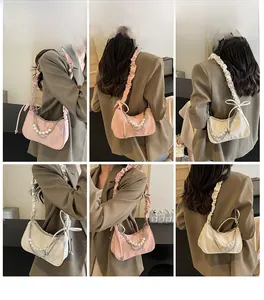 Collage de sacs sous les bras plissés avec chaînes de perles en rose et beige portés