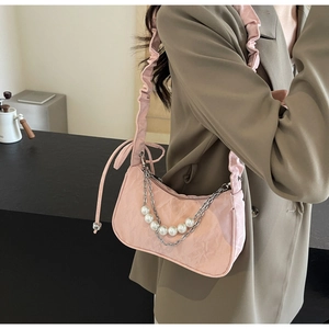 Détail du sac hobo plissé rose avec chaîne de perles et accents métalliques à l'épaule
