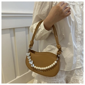 Detailed view of brown crossbody bag with silver hearts and pearl chain decoration