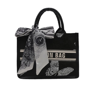 Black canvas tote bag with butterfly embroidery, top handle, and decorative silk scarf