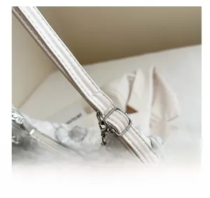 Close-up of adjustable strap with silver buckle on a white tote bag with butterfly patterns