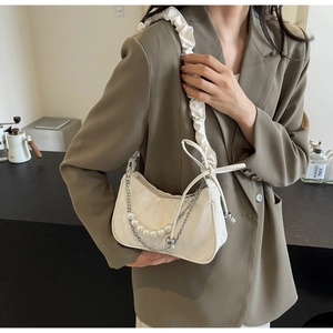 Détail du sac à bandoulière blanc plissé avec perles et texture de cuir travaillée