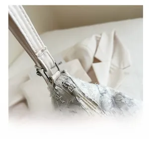 Detail of silver smooth zipper and textured lace butterfly fabric on white canvas tote bag