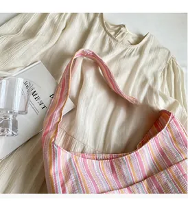 Detail of colorful striped canvas tote bag with woven texture on soft fabric background