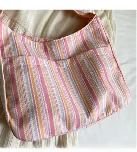 Close-up of pastel striped canvas fabric with soft pleat texture and front pocket