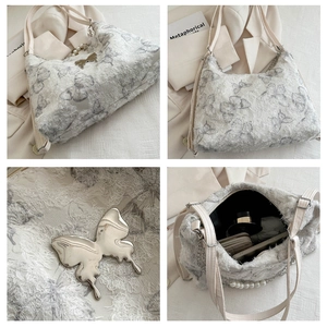 Detail of large canvas tote bag showing butterfly patterns and pearl chain accessories