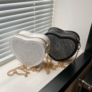 Elegant heart-shaped handbags with silver studs and gold chains in black and white
