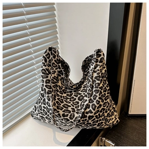 Detail of the high-capacity leopard print tote bag with thick canvas texture on wood