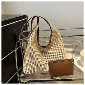 Detail of hollow woven beach tote bag with a brown faux leather inner pouch